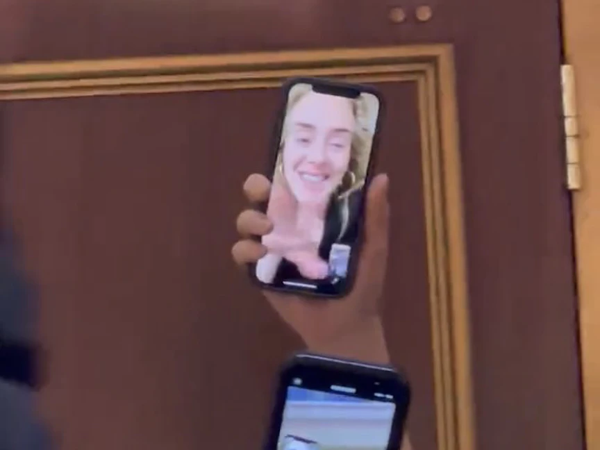 "أديل" خلال اعتذارها لبعض الجمهور عبر "فيس تايم" عن تأجيل حفلها - Twitter/@lqvesadele