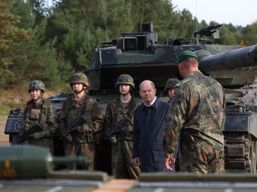 المستشار الألماني أولاف شولتز يتحدث مع جنود أمام دبابة طراز "ليوبارد 2" أثناء زيارة للجيش الألماني خلال مناورات تدريبية في أوستينهولتس شمالي ألمانيا. 17 أكتوبر 2022 - AFP