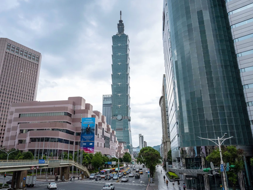 سيارات تمرّ أمام مبانٍ في تايبه - 3 يونيو 2021 - Bloomberg