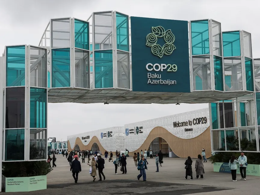 أشخاص يسيرون عند مدخل موقع انعقاد مؤتمر الأمم المتحدة لتغير المناخ COP29 في باكو بأذربيجا. 11 نوفمبر 2024 - Reuters