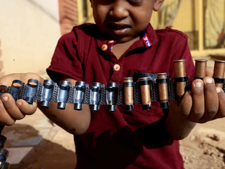 صبي يحمل خراطيش رصاص مع استمرار الاشتباكات بين قوات الدعم السريع والجيش في الخرطوم بحري، السودان. 13 مايو 2023 - Reuters