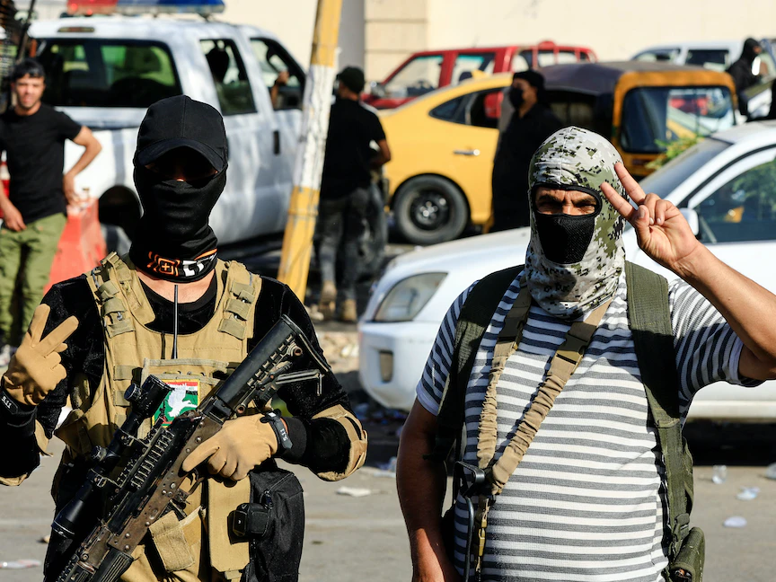 أعضاء بـ"سرايا السلام" التابعة للتيار الصدري يلوحون بعلامة النصر بعد اشتباكات خارج المنطقة الخضراء بوسط بغداد. 30 أغسطس 2022 - REUTERS