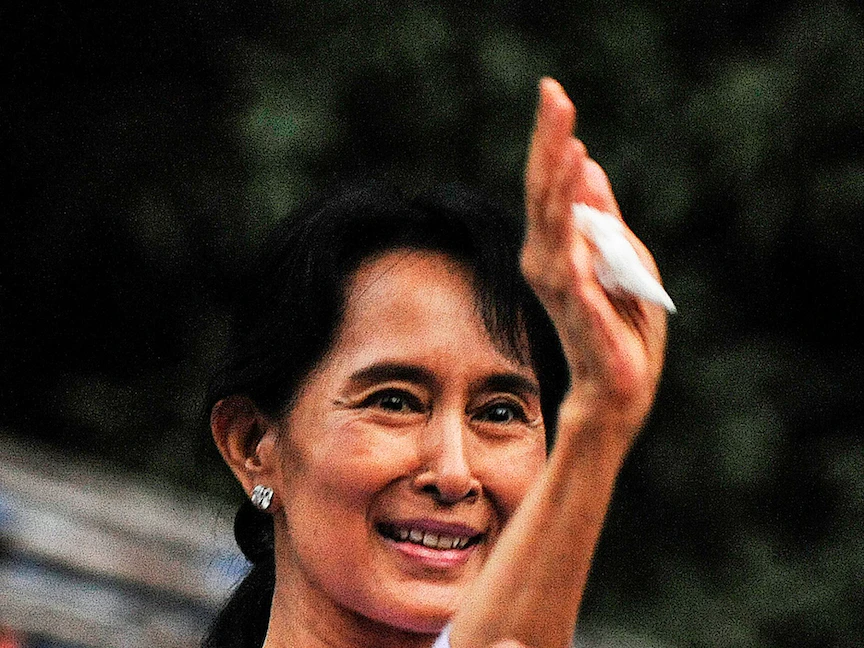 زعيمة المعارضة في ميانمار أونج سان سو تشي تلوح لأنصارها بعد إطلاق سراحها من المنزل المطل على البحيرة الذي كان سجنها طوال العقدين الماضيين في يانغون. 13 نوفمبر 2010 - AFP