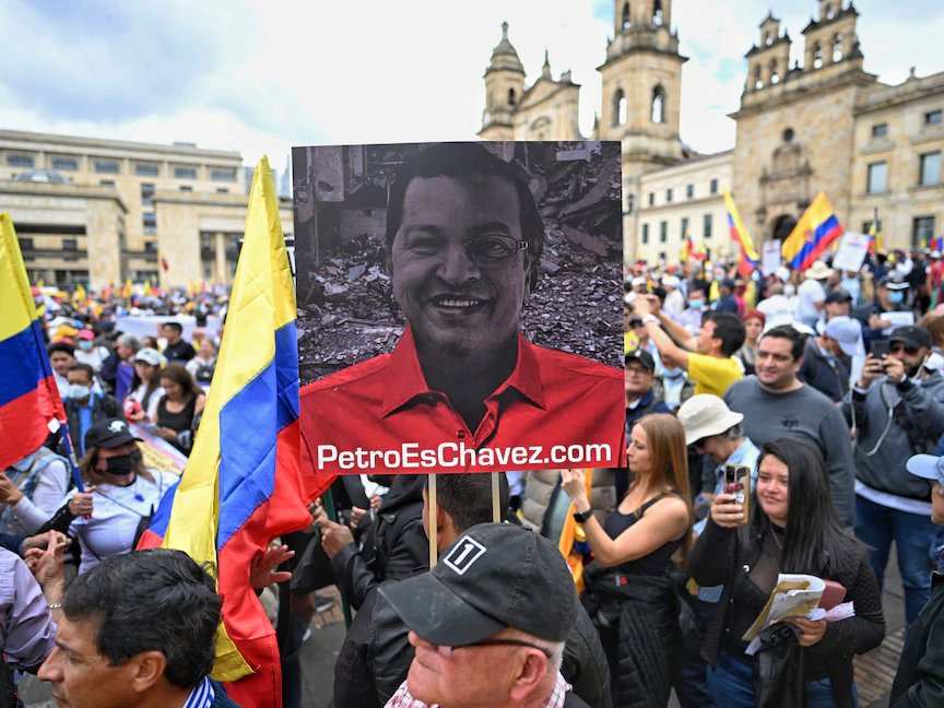 لافتة تجمع بين نصف وجه الرئيس الفنزويلي الراحل هوجو تشافيز (يسار) وجوستافو بيترو مكتوب عليها "بيترو هو شافيز" خلال مظاهرة في العاصمة الكولومبية بوجوتا- 15 فبراير 2023 - AFP