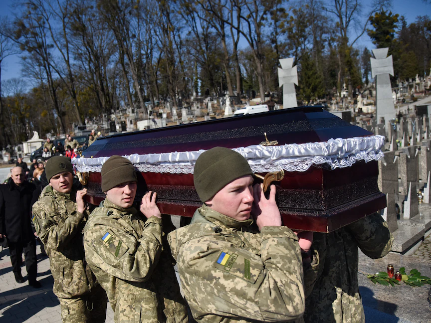 جنود أوكرانيون يحملون نعش الميجور إيفان سكريبينيك الذي سقط في ضربة صاروخية روسية على قاعدة أوكرانية، مقبرة ليشاكيف، لفيف. 17 مارس 2022 - REUTERS