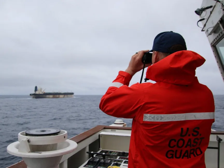 عنصر في خفر السواحل الأميركي ينظر من خلال منظار إلى السفينة مارينيرا (سابقا بيلا 1). 7 يناير 2026 - REUTERS