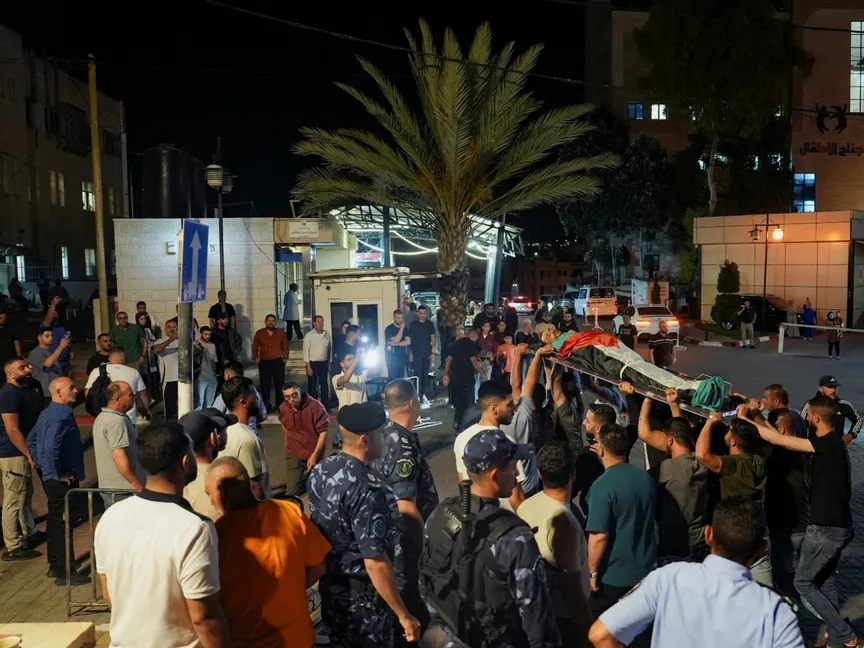 فلسطينيون يحملون جثمان فلسطيني قتله مستوطنون إسرائيليون بالقرب من مستشفى في رام الله بالضفة الغربية المحتلة. 25 يونيو 2025 - Reuters
