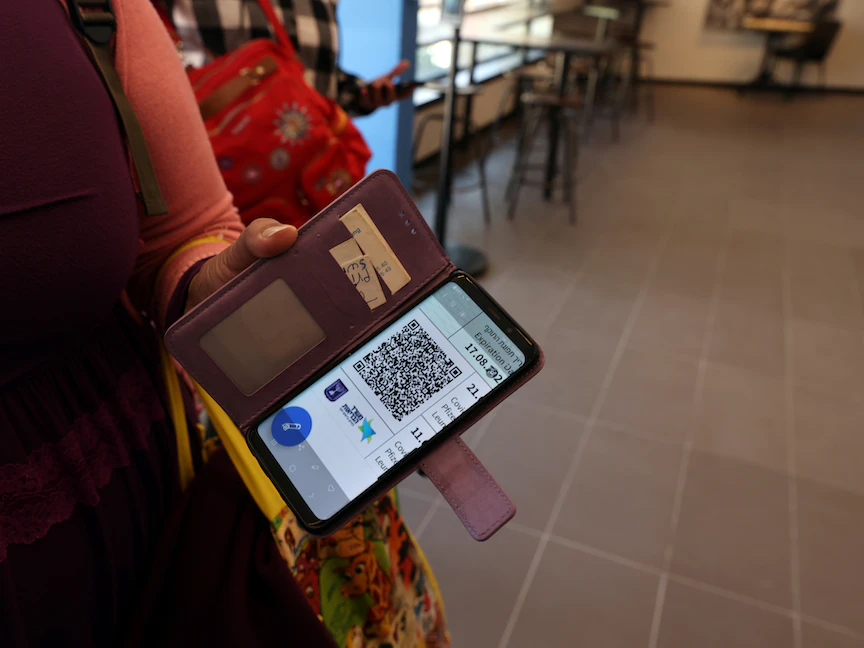 امرأة في صالة ألعاب رياضية بتل أبيب تُظهر "الممرّ الأخضر" على هاتفها الخليوي، الذي يثبت تطعيمها ضد فيروس كورونا - 21 فبراير 2021 - REUTERS