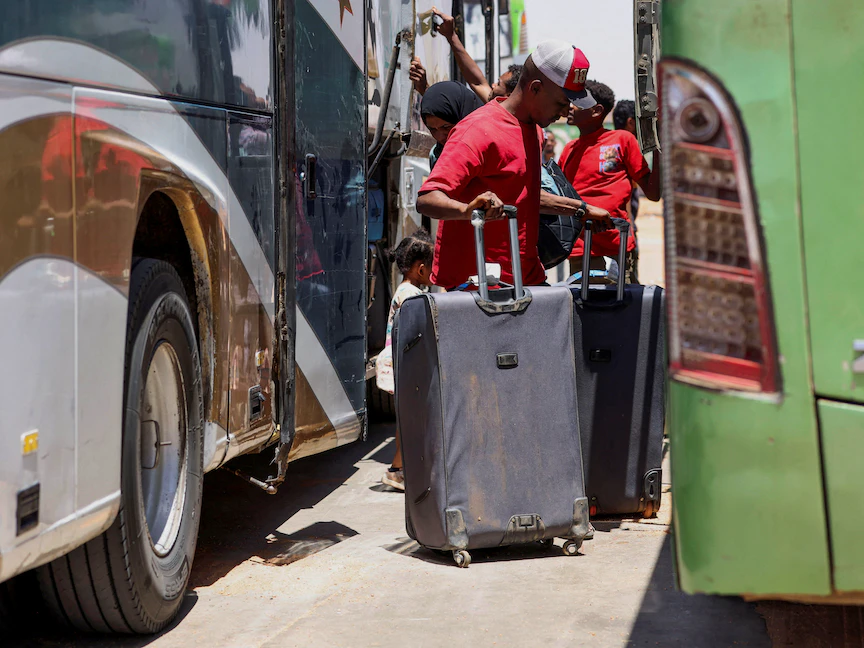 أشخاص يقفون بجوار حافلات في مدينة أبو سمبل المصرية على الحدود السودانية بعد فرارهم من الخرطوم. 28 أبريل 2023 - REUTERS