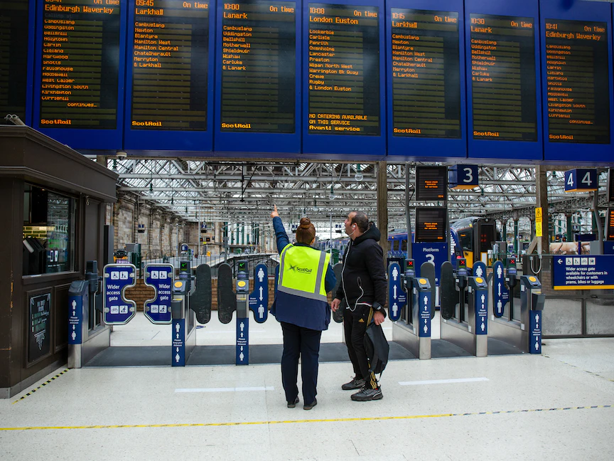 موظفة تساعد مسافراً بمحطة جلاسكو سنترال للقطارات وسط أكبر إضراب لعمال السكك الحديدية في بريطانيا منذ 30 عاماً – 21 يونيو 2022 - Bloomberg