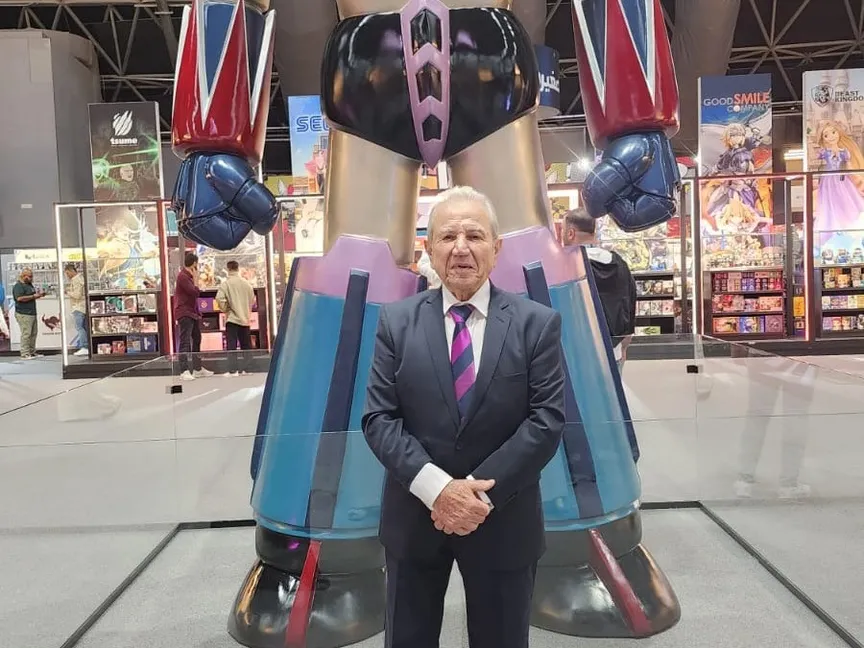 الممثل اللبناني جهاد الأطرش أمام مجسّم جريندايزر في معرض الكتاب بجدة - الشرق