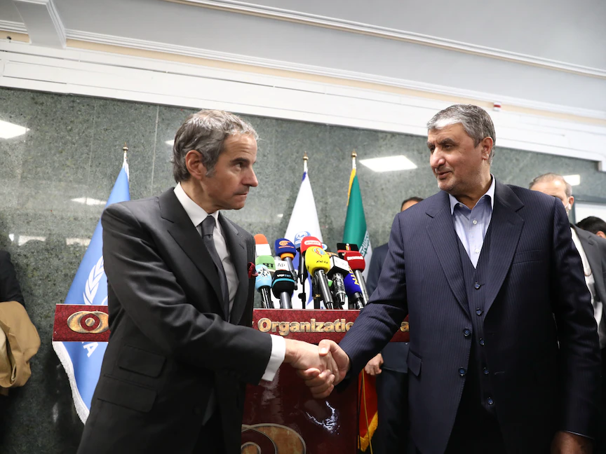 رئيس منظمة الطاقة الذرية الإيرانية محمد إسلامي يصافح المدير العام للوكالة الدولية للطاقة الذرية رفائيل جروسي، بعد مؤتمر صحافي في طهران. 5 مارس 2022 - REUTERS