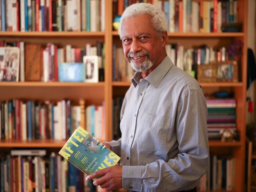 الروائي عبد الرزاق قرنح يحمل كتابه الجديد "آفتر لايفز" في مكتبة منزله في بريطانيا- 7 أكتوبر 2021 - REUTERS