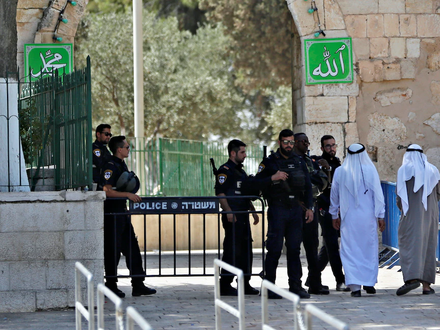 فلسطينيون يسيرون بجانب قوات أمن إسرائيلية في البلدة القديمة بالقدس - 25 يوليو 2017 - REUTERS