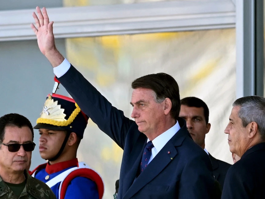 الرئيس البرازيلي جايير بولسونارو يحيّي مؤيديه إلى جانب وزير دفاعه براجا نيتو (يمين)، وقائد البحرية ألمير غارنييه (يسار)، خلال عرض للمركبات العسكرية أمام قصر بلانالتو في العاصمة برازيليا، 10 أغسطس 2021 - AFP