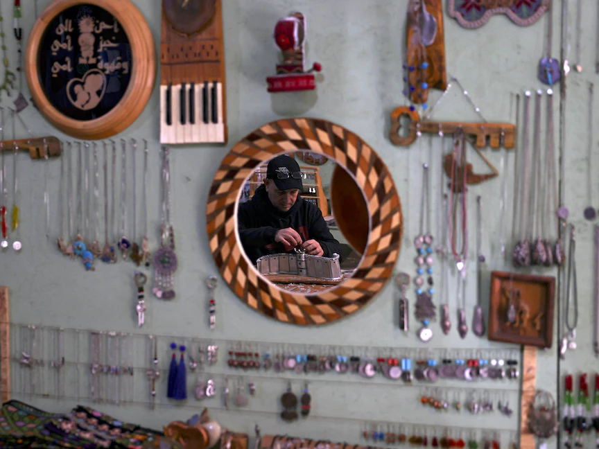 الفلسطيني أكرم الوعرة يعمل على قطعة زينة باستخدام قنابل الغاز المسيل للدموع وأسلحة إسرائيلية أخرى في ورشته بالقرب من مدينة بيت لحم بالضفة الغربية. 2 فبراير 2023 - AFP