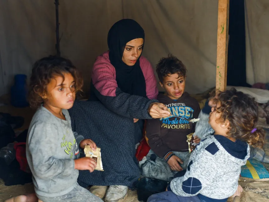 عائلة فلسطينية تحتمي داخل خيمة في مخيم النصيرات وسط عاصفة جوية. غزة. 11 ديسمبر 2025 - Reuters