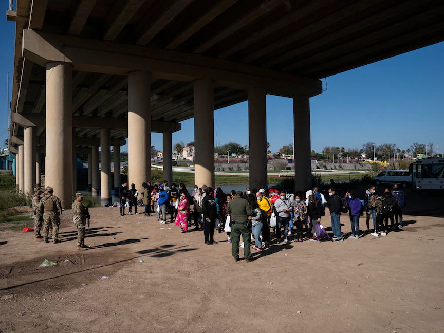 مهاجرون ينتظرون دورهم ليقوم أحد عناصر شرطة دوريات الحدود الأميركية بتدوين بياناتهم في مدينة إيجل باس بولاية تكساس. 20 ديسمبر 2022 - AFP