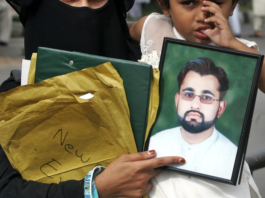 ربيعة يعقوب، زوجة مجيد خان، تحمل صورة لزوجها مع ابنتها منال خلال تظاهرة في إسلام آباد - 22 سبتمبر 2006 - REUTERS