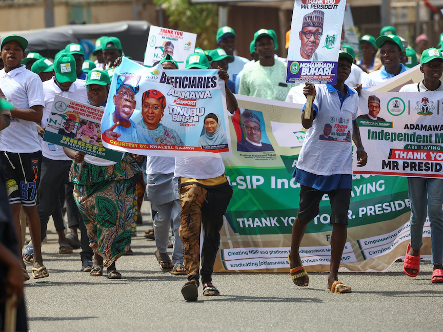 أنصار حزب مؤتمر التقدميين الحاكم يحملون ملصقات ولافتات للرئيس النيجيري محمد بخاري والمرشح الرئاسي بولا أحمد تينوبو خلال حملة حزبية في يولا. 22 فبراير 2023 - REUTERS