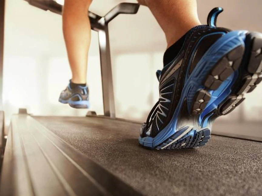 رجل يمارس رياضة الهرولة على آلة المشي "تريدميل" في صالة رياضية - مايو كلينيك
