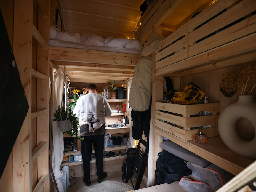 الفنان البريطاني هاريسون مارشال في منزله المكون من صندوق قمامة في لندن. 6 مارس 2023 - REUTERS