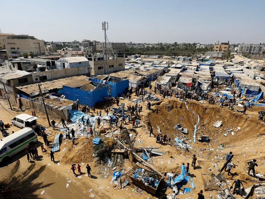 فلسطينيون يتفقدون موقع غارة إسرائيلية استهدفت مستودعاً للأدوية في دير البلح وسط قطاع غزة. 1 أغسطس 2026 - REUTERS