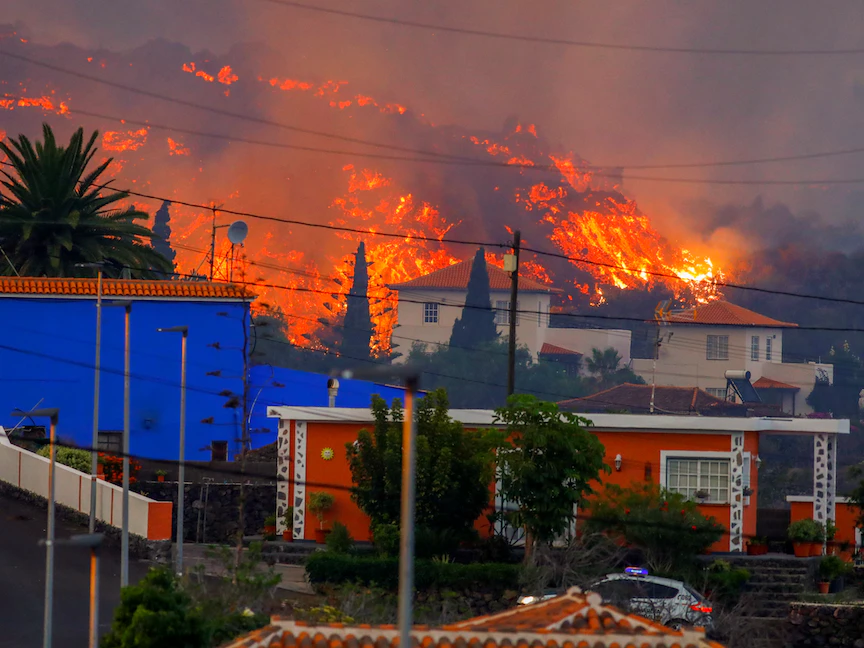 تدفقات الحمم البركانية خلف المنازل بعد ثوران بركان في جزيرة لا بالما، 20 سبتمبر 2021 - REUTERS