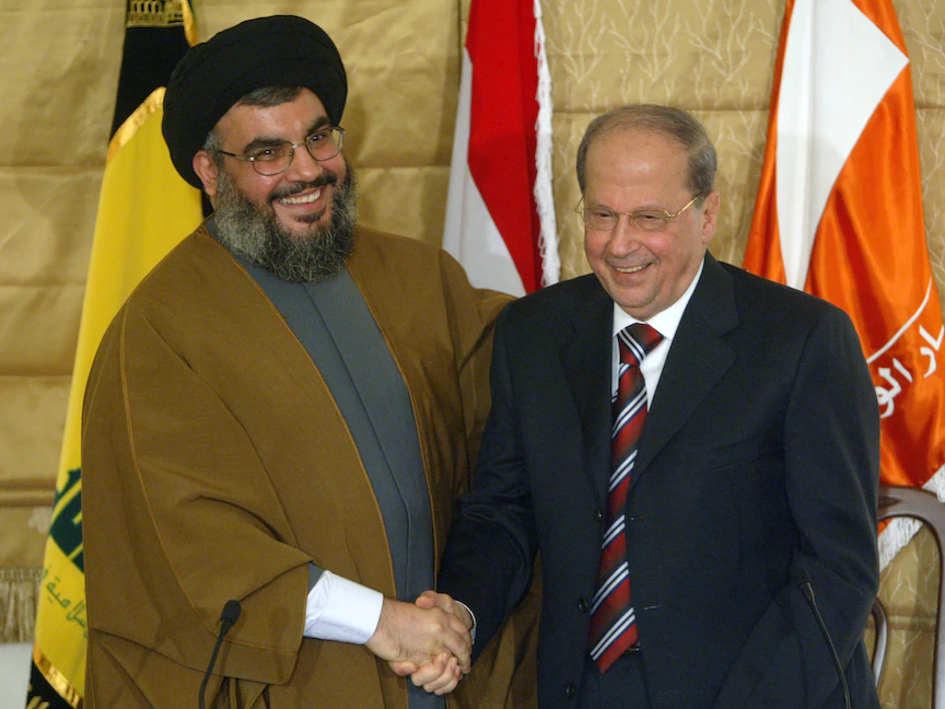 الأمين العام لـ"حزب الله" اللبناني حسن نصر الله يصافح زعيم التيار الوطني الحر ميشال عون بعد توقيع "تفاهم مار مخايل" بيروت- 6 فبراير 2006 - REUTERS