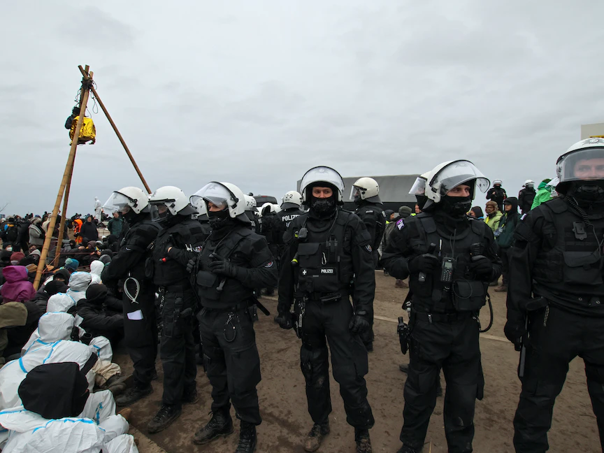 عناصر الشرطة أمام نشطاء بيئيين يتظاهرون في قرية لوتسيرات بألمانيا. 10 يناير 2023 - REUTERS