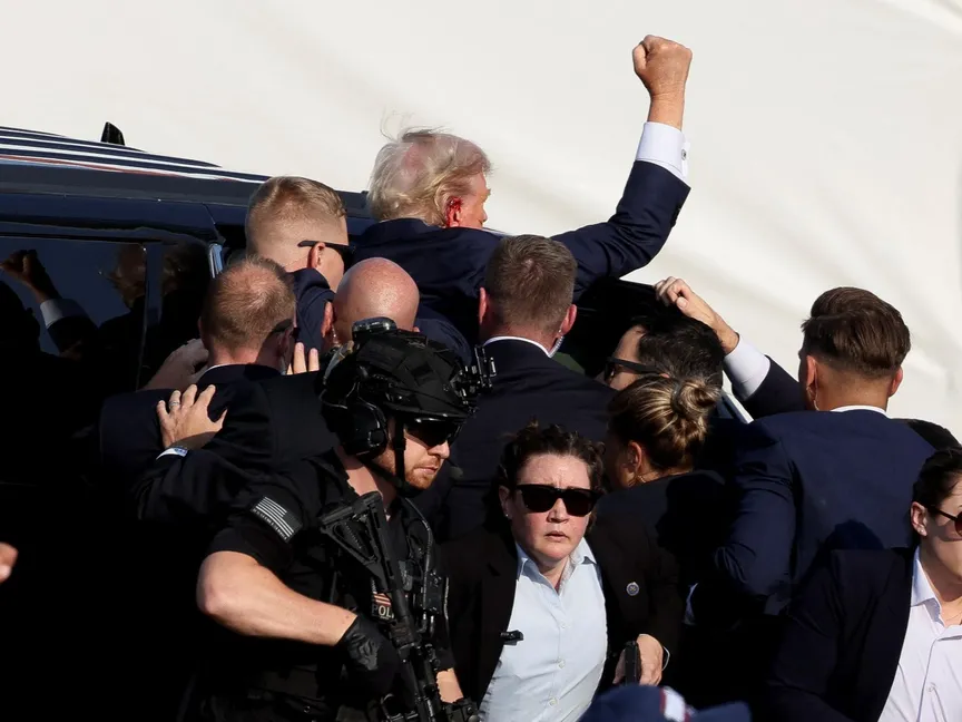 المرشح الجمهوري للرئاسة والرئيس الأميركي السابق دونالد ترمب يسير برفقة أفراد الخدمة السرية الأميركية بعد إصابته برصاصة في أذنه اليمنى خلال تجمع انتخابي في بنسلفانيا بالولايات المتحدة. 13 يوليو 2024 - REUTERS