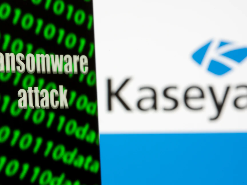 عبارة هجوم ببرنامح الفدية تظهر على هاتف محمول أمام شعار شركة كاسيا الأميركية التي تعرضت لهجوم إلكتروني من هذا النوع، 6 يوليو 2021 - REUTERS