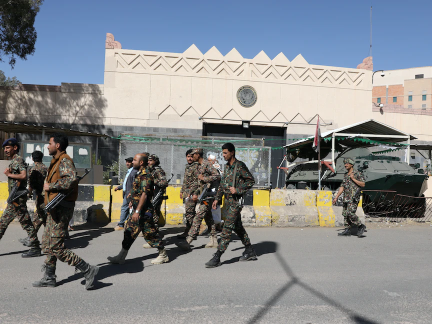 مقاتلون من جماعة الحوثي في اليمن يمرون أمام مقر السفارة الأميركية المغلق في صنعاء، 18 يناير 2021 - REUTERS