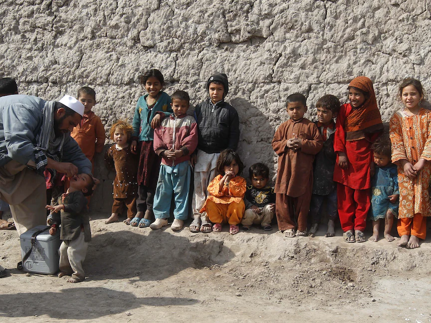 طفل أفغاني يتلقى تطعيم ضد شلل الأطفال بينما يقف الآخرون في طابور خلال حملة في ضواحي جلال آباد، أفغانستان - 11 فبراير 2013 - REUTERS