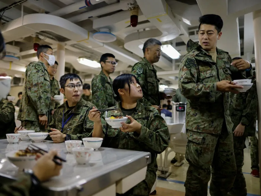 جنود في الجيش الياباني أثناء تناول العشاء على متن سفينة تابعة لقوة الدفاع الذاتي البحرية اليابانية JS Osumi في أوكيناوا. 14 نوفمبر 2023 - Reuters