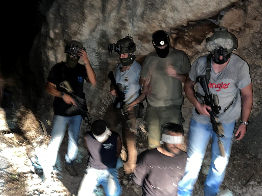 قوات الأمن الإسرائيلية تقف بجانب الأسيرين الفلسطينيين زكريا الزبيدي ومحمود العارضة بعد اعتقالهما، 11 سبتمبر2021 - REUTERS