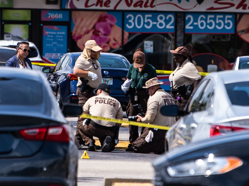 ضباط شرطة ميامي يجمعون الأدلة من الموقع الذي شهد إطلاق النار - 30 مايو 2021 - AFP
