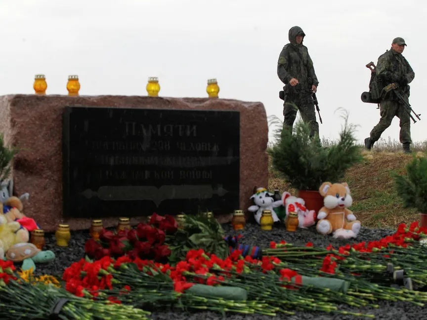 جنديان من قوات الانفصاليين في "دونيتسك" أمام نصب تذكاري لضحايا تحطم طائرة الخطوط الجوية الماليزية MH17، في شرق أوكرانيا - REUTERS