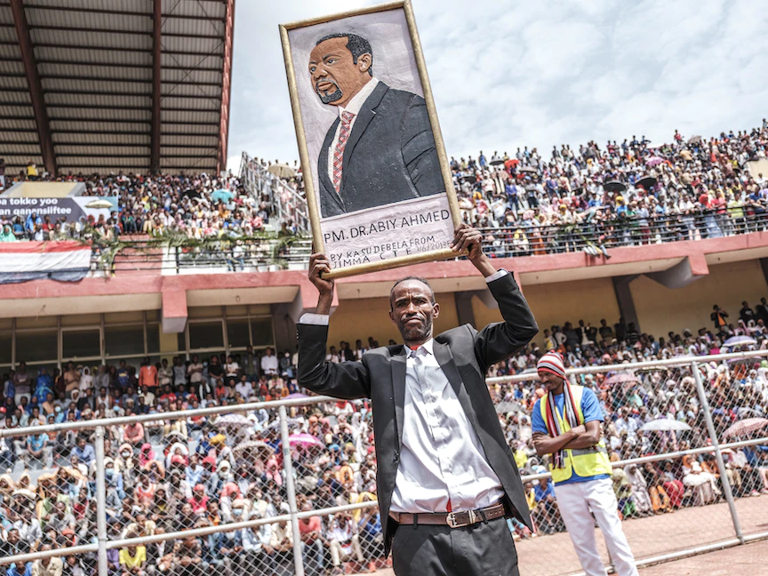 رجل يحمل صورة لرئيس الوزراء الإثيوبي أبي أحمد في ملعب بمدينة جيما، 16 يونيو 2021 - AFP