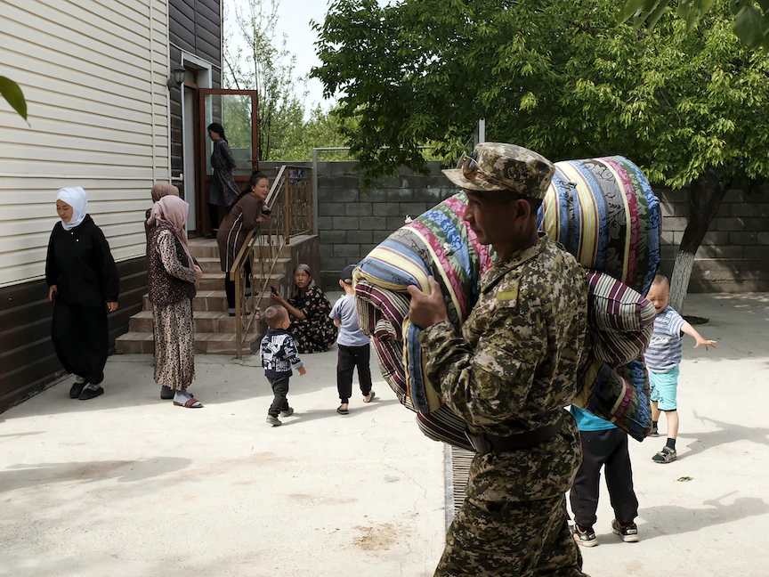 جندي قيرغيزي يحمل مراتب للمواطنين الذين تم إجلاؤهم من المناطق المتاخمة لطاجيكستان في أعقاب القتال على طول الحدود المتنازع عليها بين قرغيزستان وطاجيكستان، 30 أبريل 2021 - AFP