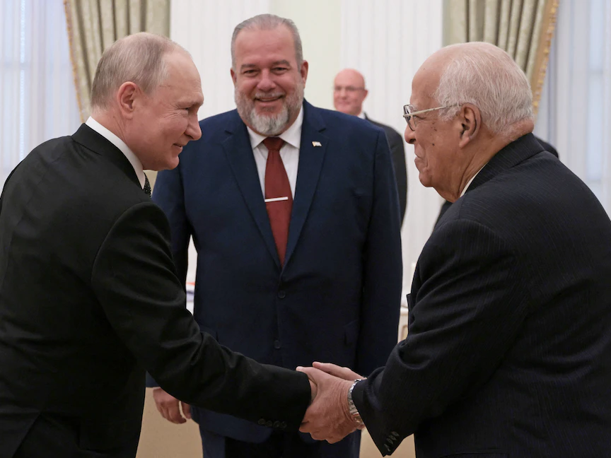 الرئيس الروسي فلاديمير بوتين (يسار) يصافح نائب رئيس الوزراء الكوبي ريكاردو كابريساس رويز (يمين) ويقف بينهما رئيس الوزراء الكوبي مانويل ماريرو كروز قبل اجتماع في الكرملين بالعاصمة موسكو. 14 يونيو 2023 - REUTERS