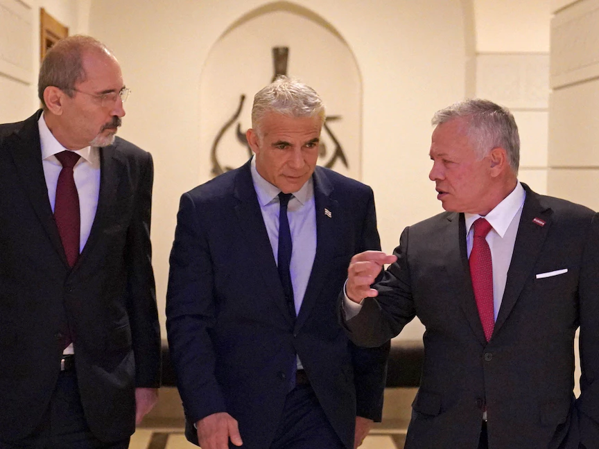 ملك الأردن عبد الله الثاني (يمين) ووزير خارجيته أيمن الصفدي (يسار) خلال استقبال رئيس الوزراء الإسرائيلي يائير لبيد في قصر الحسينية في عمان - 27 يوليو 2022 - AFP