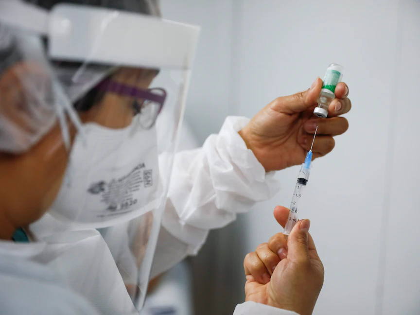 أحد أفراد الطواقم الطبيعة يعمل على تجهيز جرعة من لقاح كورونا في السلفادور - REUTERS