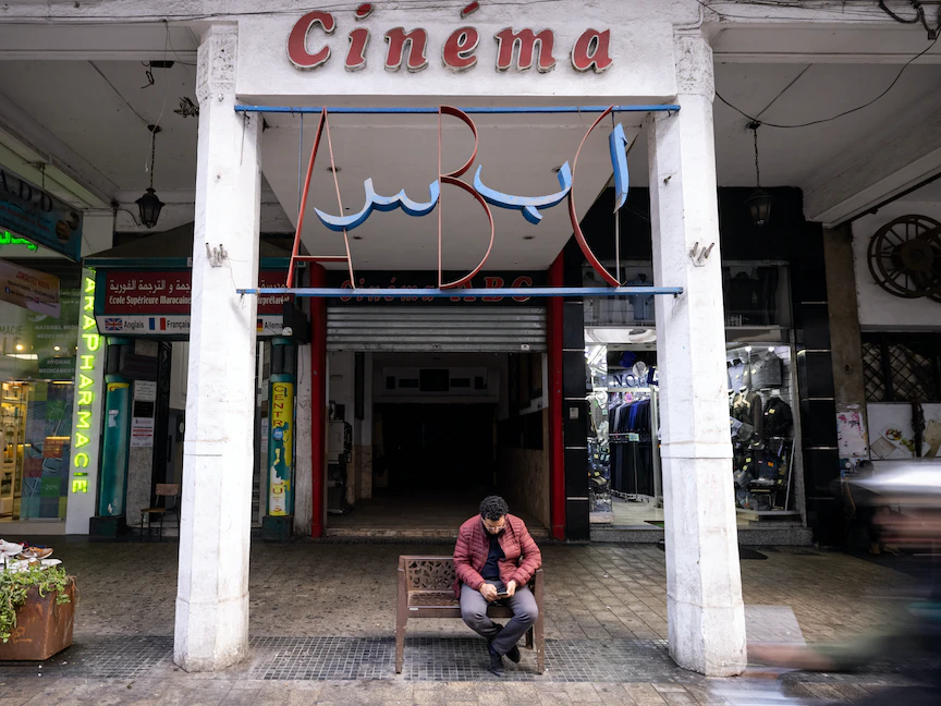 رجل يجلس عند مدخل سينما ABC، في مدينة الدار البيضاء غرب المغرب- 24 يناير 2022 - AFP