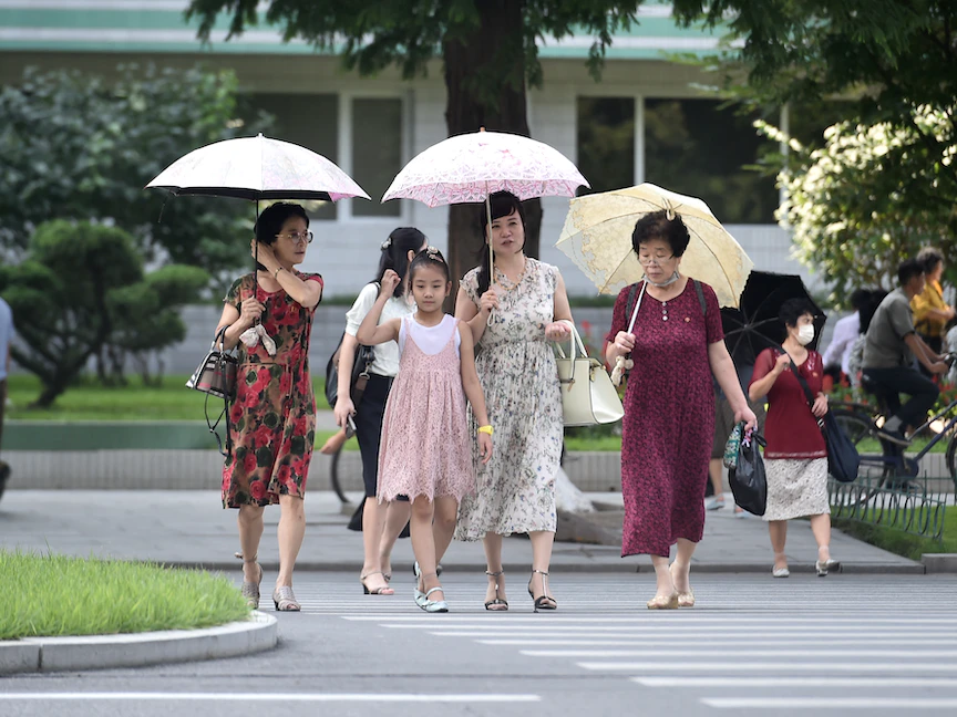 مشاة يسيرون بأحد شوارع العاصمة الكورية الشمالية بيونج يانج بعد انتشار فيروس كورونا. 12 أغسطس 2022 - AFP