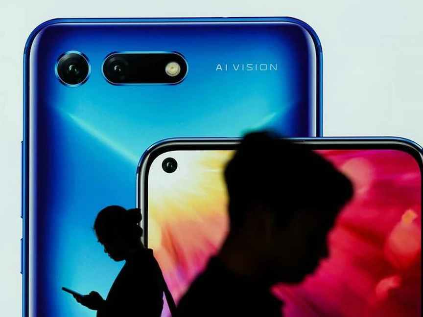 أشخاص أمام لوحة إعلانية لهاتف أونور - REUTERS