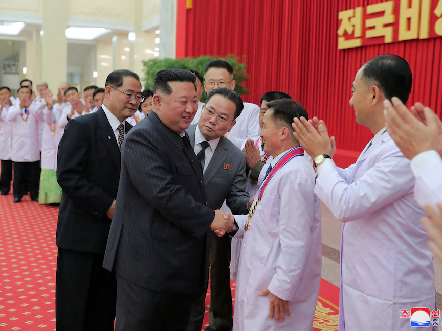 زعيم كوريا الشمالية كيم جونج أون يصافح أعضاء الهيئات الصحية بعد جهودهم في مكافحة فيروس كورونا- 10 أغسطس 2022 - via REUTERS