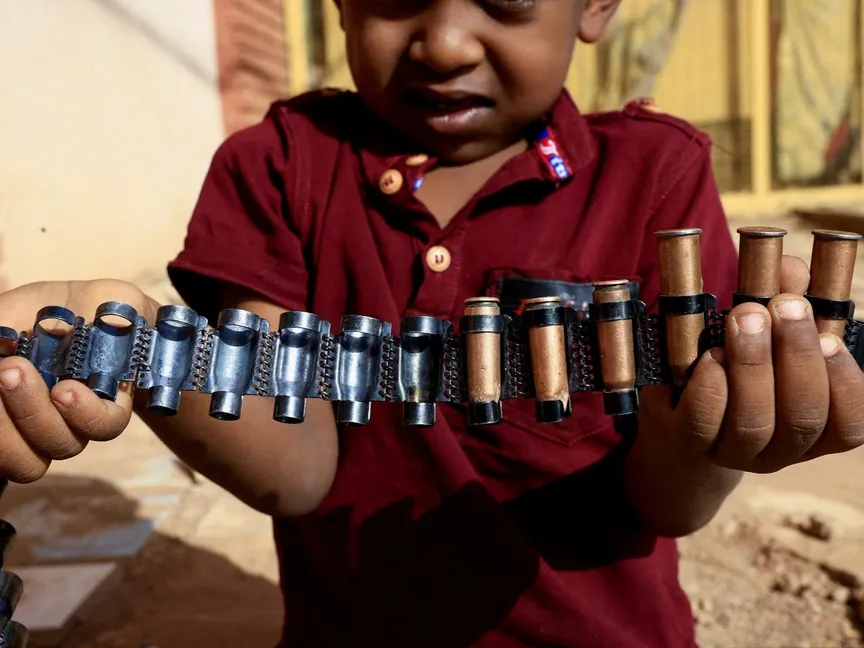 طفل سوداني يمسك خراطيش بندقية. الخرطوم، السودان. 13 مايو 2023 - Reuters