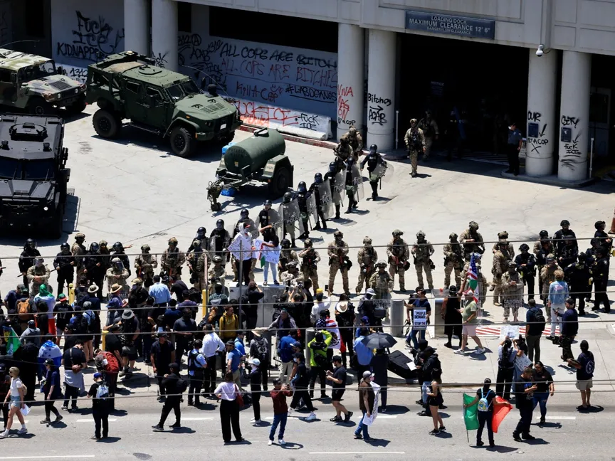 يقف أفراد من أجهزة الأمن بجانب المتظاهرين خارج مبنى إدوارد آر. رويال الفيدرالي خلال احتجاج على حملات تفتيش الهجرة الفيدرالية في وسط مدينة لوس أنجلوس، كاليفورنيا، الولايات المتحدة الأميركية. 10 يونيو 2025 - Reuters