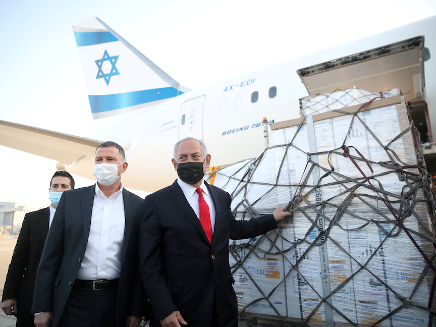 رئيس الوزراء الإسرائيلي بنيامين نتنياهو، ووزير الصحة يولي إدلشتاين، يحضران وصول طائرة تحمل شحنة من لقاحات فايزر المضادة لفيروس كورونا، في مطار بن غوريون - 10 يناير 2021 - REUTERS